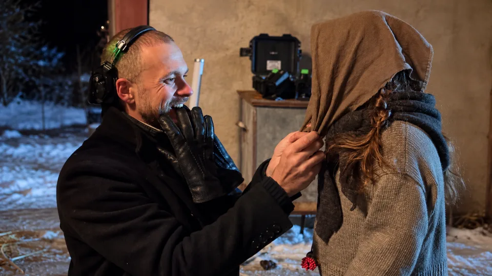 Director wearing headphones adjusts the actress's scarf-1.